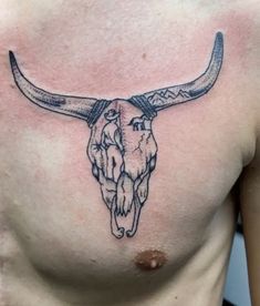 a bull skull tattoo on the chest