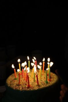 a birthday cake with many lit candles on it