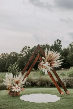 an outdoor ceremony setup with tall grass and flowers