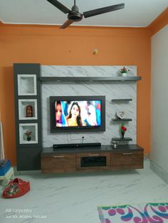 a flat screen tv sitting on top of a wooden entertainment center in a living room