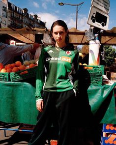 a woman standing in front of a fruit stand