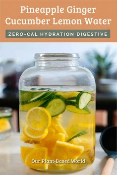 a glass jar filled with lemon water and cucumber slices on top of it