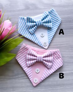 two small bow ties sitting next to each other on top of a wooden table with flowers