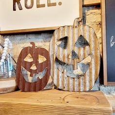 two carved pumpkins sitting next to each other on a shelf in front of a sign