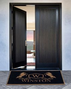 a black door with the words baldwin on it and an entrance mat in front of it