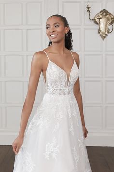 a woman in a white wedding dress standing on a wooden floor