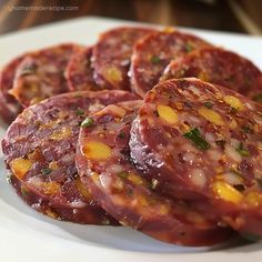 several slices of salami on a white plate