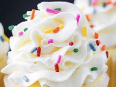 cupcakes with white frosting and colorful sprinkles