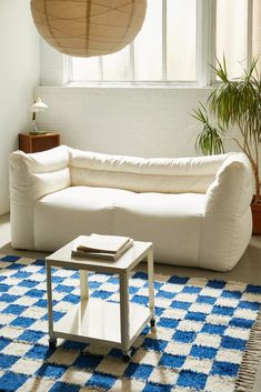 a living room with a white couch and blue rug