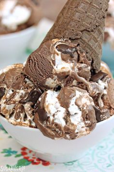 an ice cream sundae with chocolate and marshmallows in a white bowl