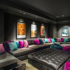 a room with couches, pillows and pictures on the wall