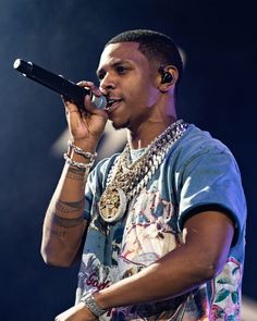 a young man holding a microphone up to his mouth while wearing headphones on stage