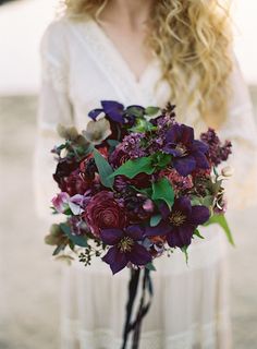 a woman holding a bouquet of flowers in her hands