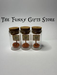 three empty glass jars with wooden tags on them and the words, the funky gifts store