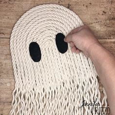 someone is making a ghost mask out of rope on the floor with two eyes and one nose