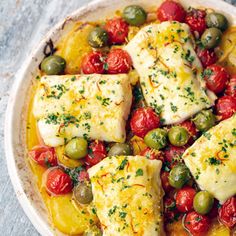 a white bowl filled with fish and olives