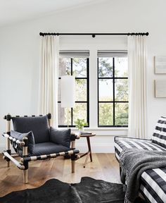 a bedroom with black and white furniture and curtains