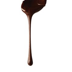 a spoon full of melted chocolate on a white background