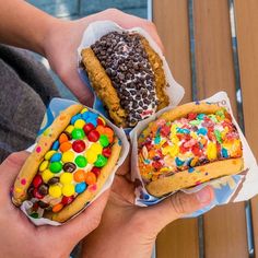 three different types of pastries in paper containers with toppings on them, one is filled with candy and the other has sprinkles