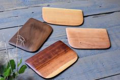 three wooden coasters sitting on top of a table next to a potted plant