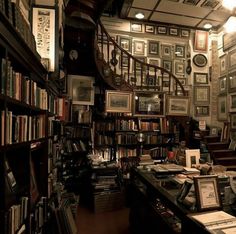 an old library with many books and pictures on the walls, along with a spiral staircase