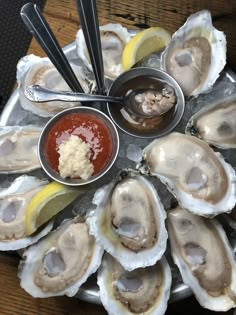 a platter filled with oysters and dipping sauce