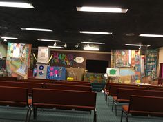 an empty classroom with chairs and bulletin boards on the wall