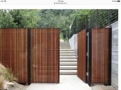 a wooden gate with metal railing and steps leading up to the top of some stairs