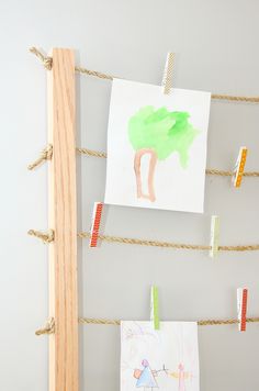 clothes pins are hanging on the clothes pegs next to some drawings and pencils