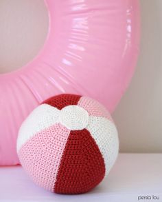 a crocheted beach ball sitting next to a pink object