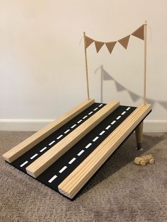 a toy train track with two cars on the tracks and a bunting banner in the background