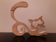 the wooden sculpture is shaped like a cat's tail and tail curled up into an eight