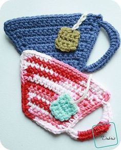 three crocheted items are sitting on a table top, one is blue and the other is red