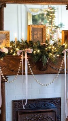 a mantel decorated for christmas with candles and garland