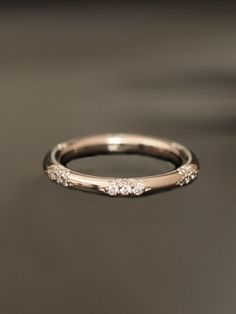 a wedding ring with three diamonds on it sitting on a table in front of a black background