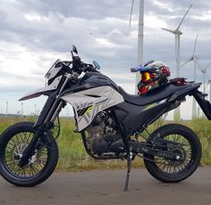 the motorcycle is parked on the side of the road near wind mills and windmills