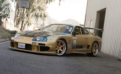 a gold sports car parked in front of a building