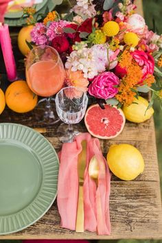 the table is set with flowers, fruit and candles for an elegant dinner or brunch