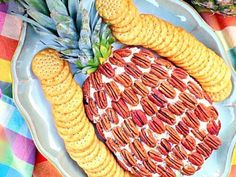 a plate with crackers, pineapples and other food items on top of it