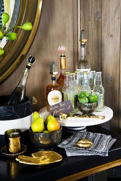 a table topped with plates and bowls filled with fruit next to a mirror on top of a wooden wall