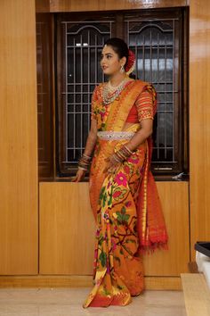 a woman in an orange and yellow sari