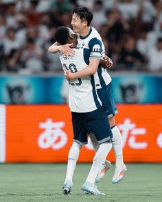 two soccer players hugging each other on the field