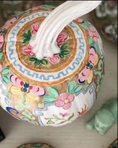 an ornately decorated vase sitting on top of a table next to other decorative items