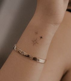 a woman's arm with a small star tattoo on the left side of her wrist