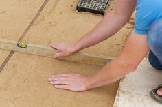 a person measuring the width of a tile floor