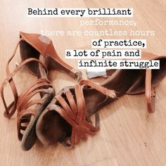 a pair of brown shoes sitting on top of a wooden floor next to a quote