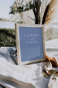 a blue card's and gifts sign sitting on top of a white table cloth