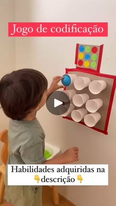 a little boy that is playing with some cups