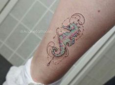 a woman's leg with a colorful seahorse tattoo on it