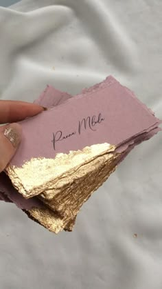 a person holding some pink and gold paper